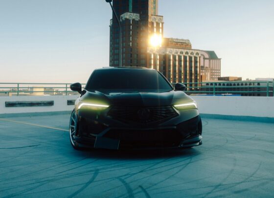 Dark car parked near a lit tower