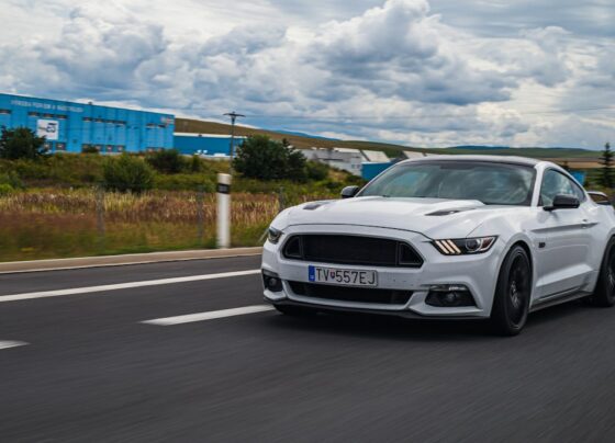 White Ford Mustang driving on a road