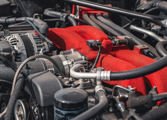 Close view of a car engine bay with a red engine cover.