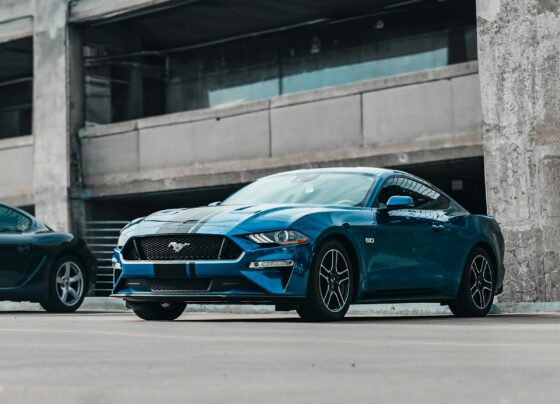 Blue Ford Mustang beside a modern building