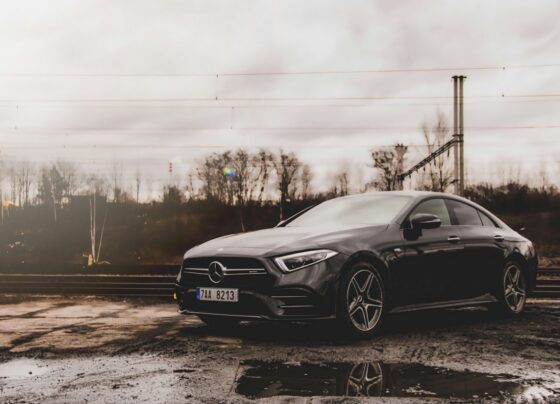 Dark Mercedes-Benz car parked under an overcast sky