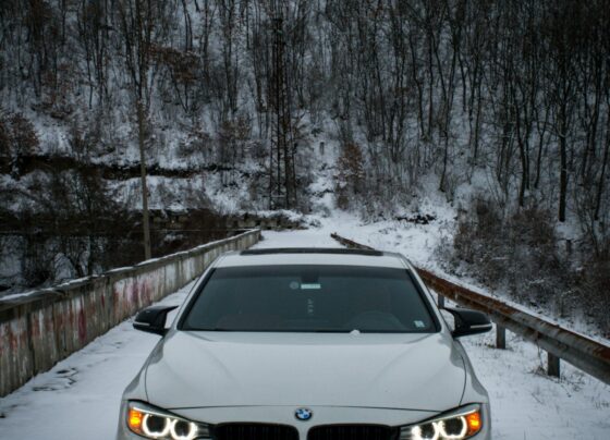 White BMW car on a snowy forest road