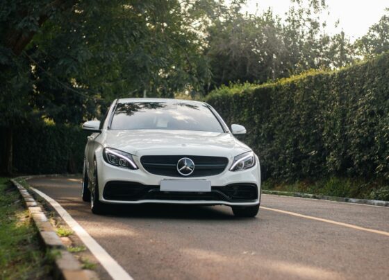 White Mercedes-Benz sedan parked beside trees
