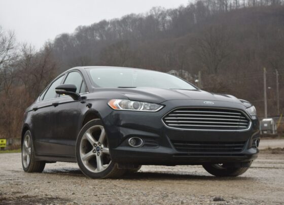 Dark Ford car parked beside a road
