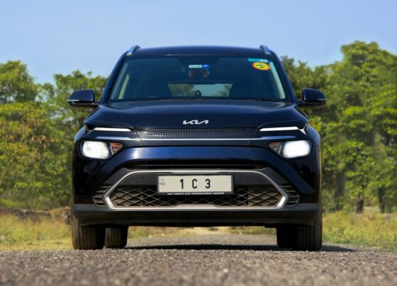 Dark Kia car parked in a field