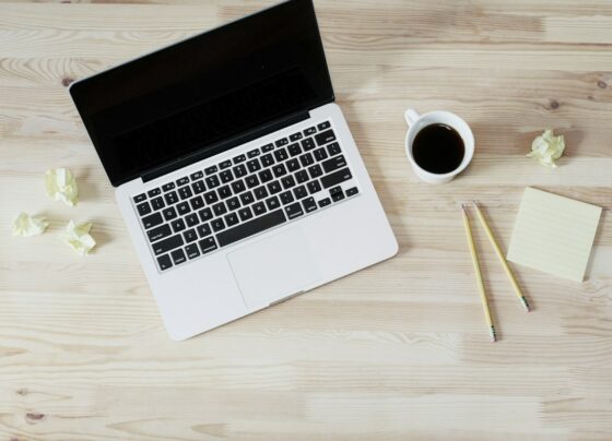 Laptop and notebook used for planning at a desk