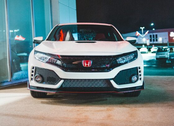 White Honda hatchback parked outside a building