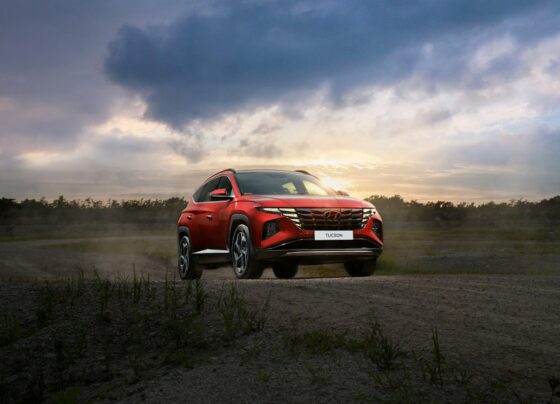 Red Hyundai vehicle parked in an open landscape
