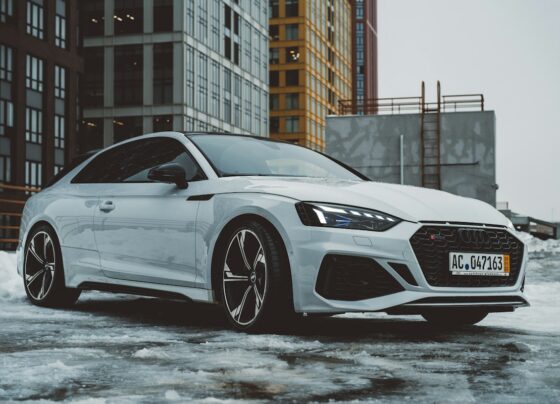 White Audi car parked beside buildings