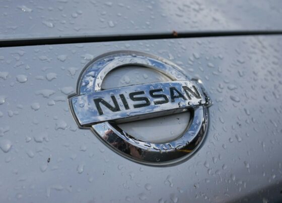 Close-up of a Nissan badge on a wet vehicle