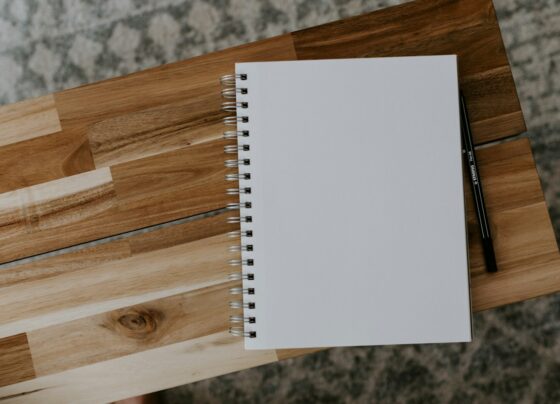Blank spiral notebook with a pencil on a wooden tabletop.