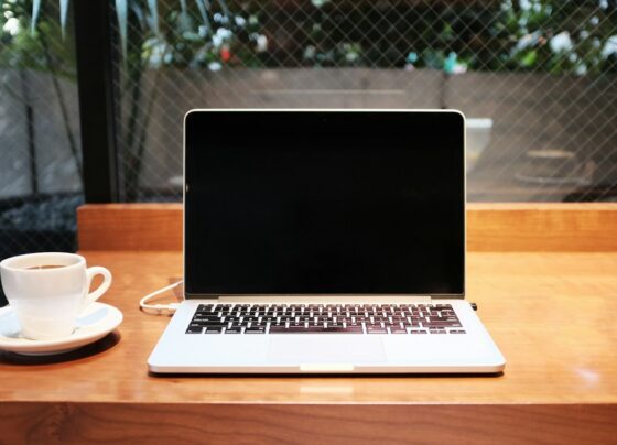 Laptop computer beside a white cup