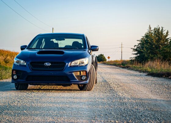 Blue Subaru sedan parked on a gravel road