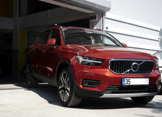 Red Volvo SUV parked beside a building