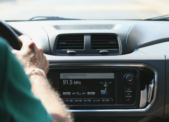 Driver beside a car radio and dashboard controls