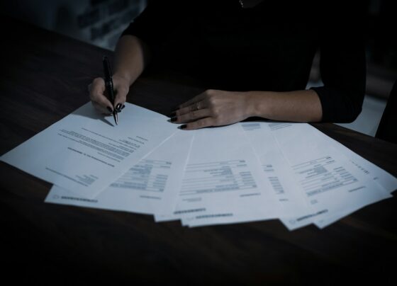 Person reviewing documents spread across a desk
