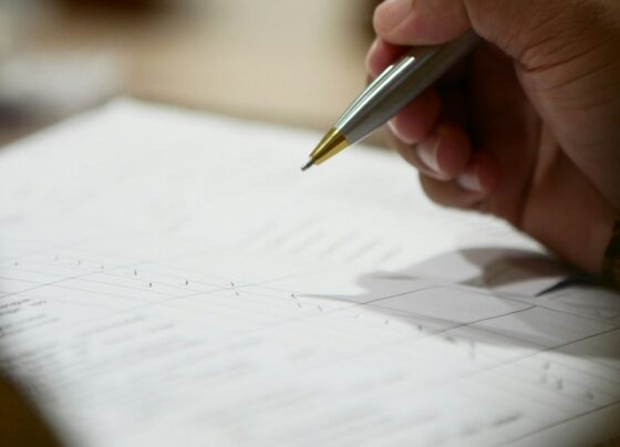 Close-up of a pen poised over a paper form