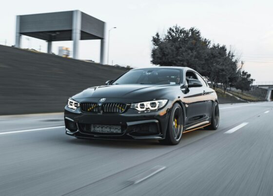 Dark BMW sedan traveling on a road